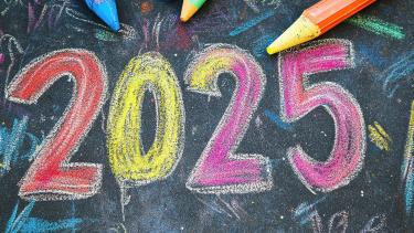 Welcome back - Happy New Year! Colourful chalk numbers drawn on a blackboard with pencil crayons in the background