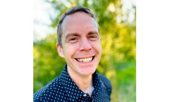 SD8 is pleased to announce the appointment of Mr. Ian Cooper as Principal of L.V. Rogers Secondary School and the REACH program, effective August 1, 2025. A man with short, sandy blond hair and a broad smile stands in front of some green bushes