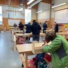 Students work at wooden benches making a variety of wooden products.