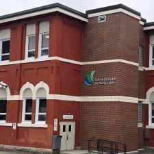A two story red brick school building housing a school district office