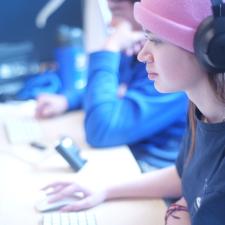 Students at a long table working on digital arts projects