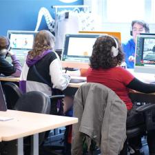 Students seated at desktop computers in a classroom.
